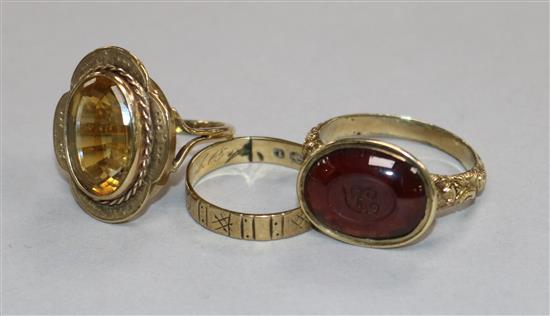 A 9ct gold wedding band, a George III garnet signet ring and a Victorian citrine ring.